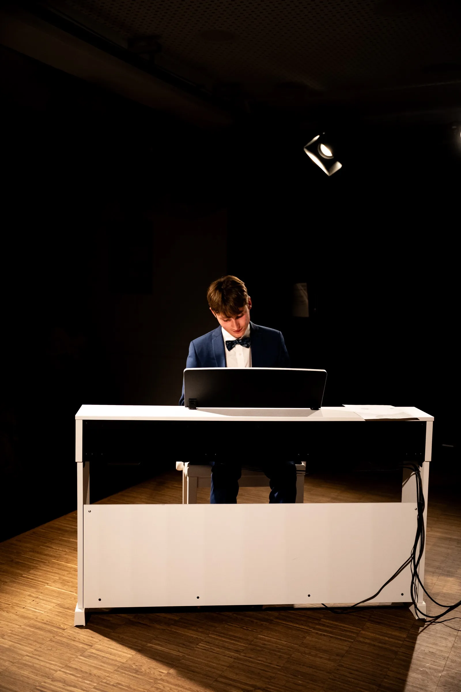 Lukas Höver at the grand piano during a concert, under stage lights